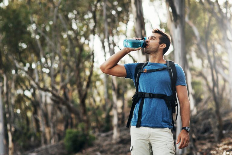 Man refreshing with water bottle during hike