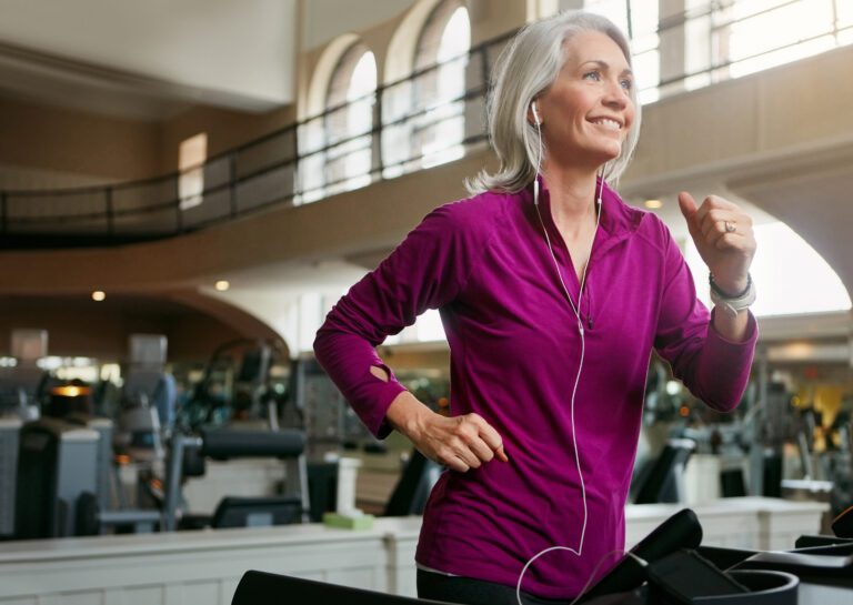 a senior woman running on the treadmill in the gym